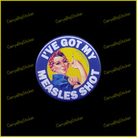 Pin-back button says, I've got my Measles Shot. Shows Rosie the Riveter holding syringe. 