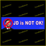 Bumper Sticker or Magnetic Bumper Sticker says, JD is NOT OK! Features photo of JD Vance with a Red Circle and diagonal line across his face. Blue background.